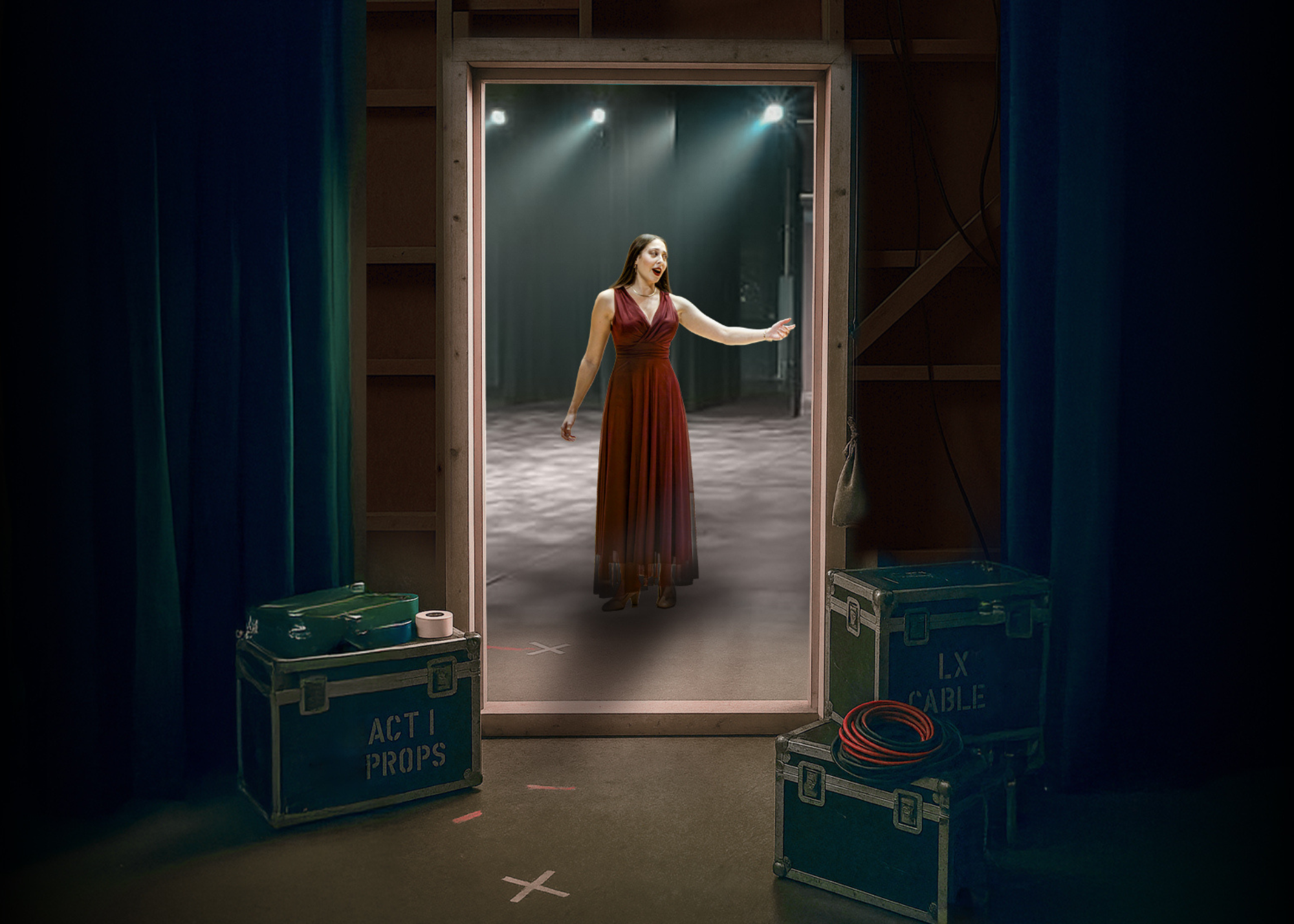 The side view from backstage of a woman in a red dress performing on an opera stage