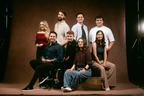 Eight people pose for a photo split up in two rows