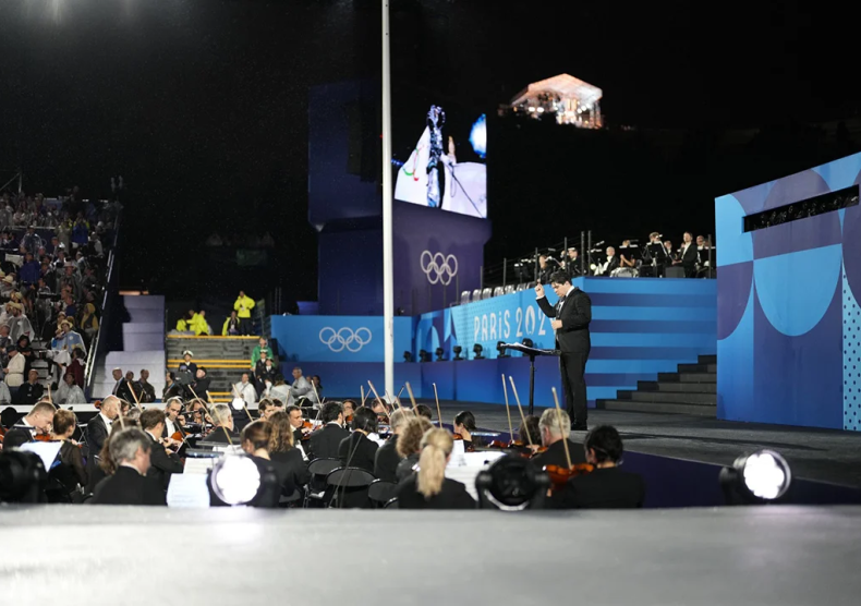 Cristian Mǎcelaru, music director of the Orchestre National de France and Shepherd School alumnus conducts during the Paris 2024 Olympics.