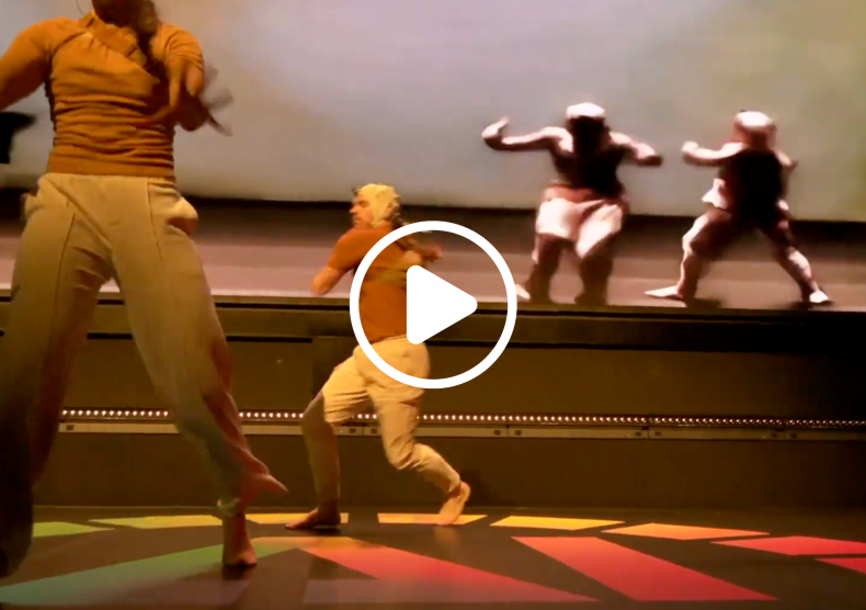 Two dancers perform with their shadows illuminated