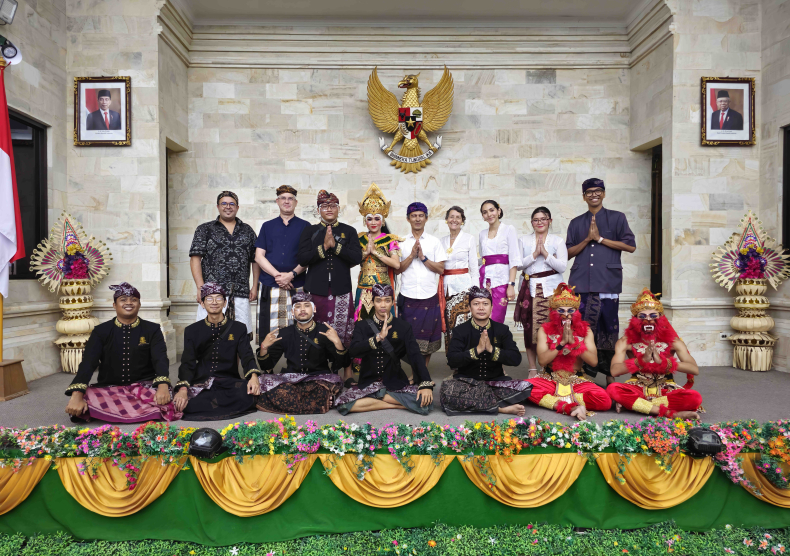 Group photo of the team in Bali; two rows with the first row seated in  Sukhasana pose