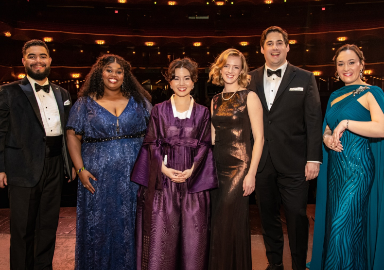 Photo of six vocalists on stage at the Met in black tie attire