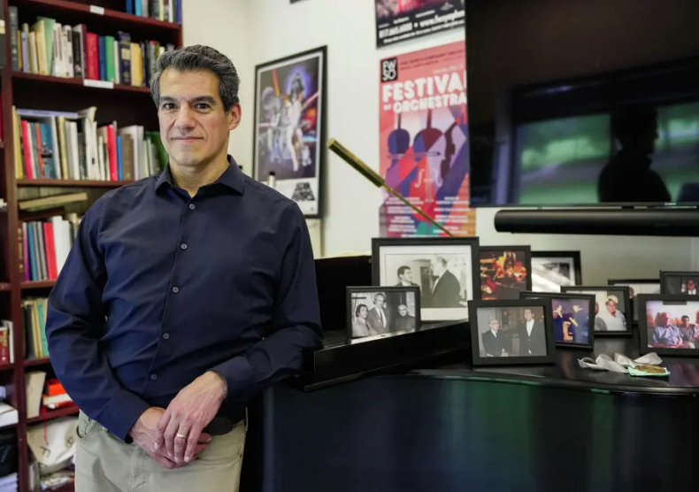 Miguel Harth-Bedoya standing at piano in his office at the Shepherd School of Music at Rice University