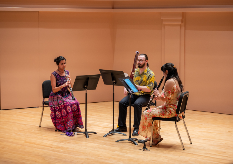 A wind trio in colorful outfits performs in Duncan Recital Hall