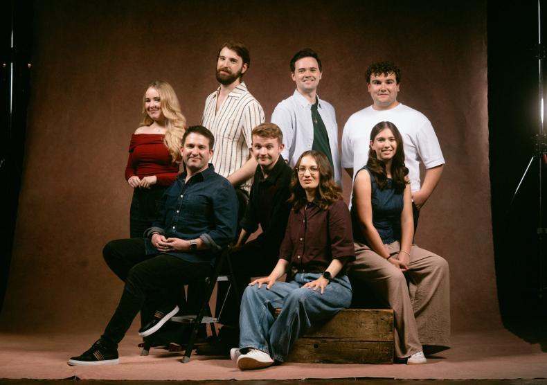 Eight people pose for a photo split up in two rows