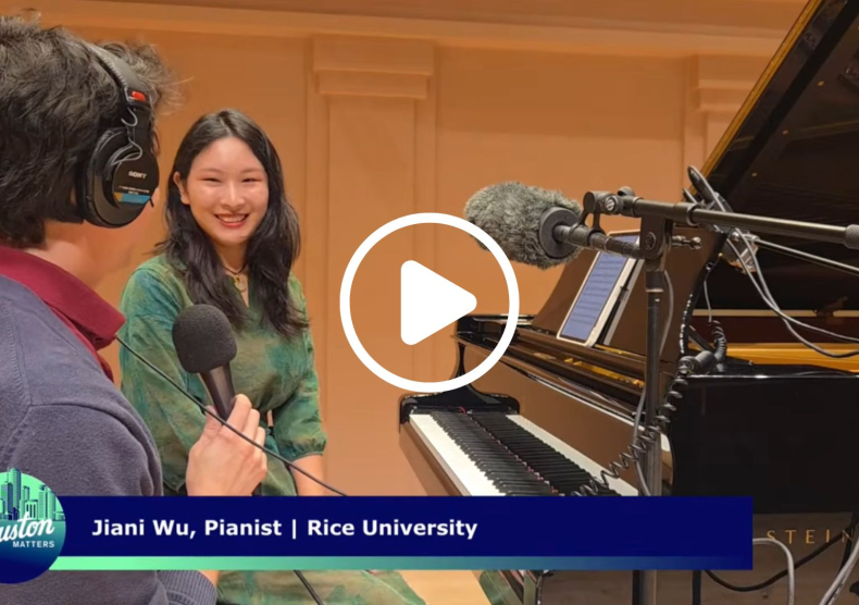 A woman seated at a piano smiles at a producer during an interview