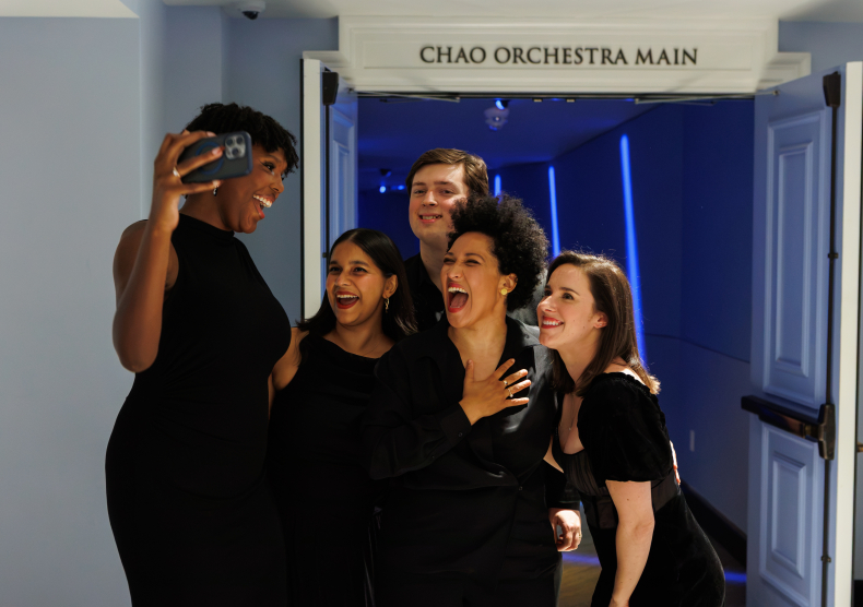 A group of musicians dressed in black take a selfie